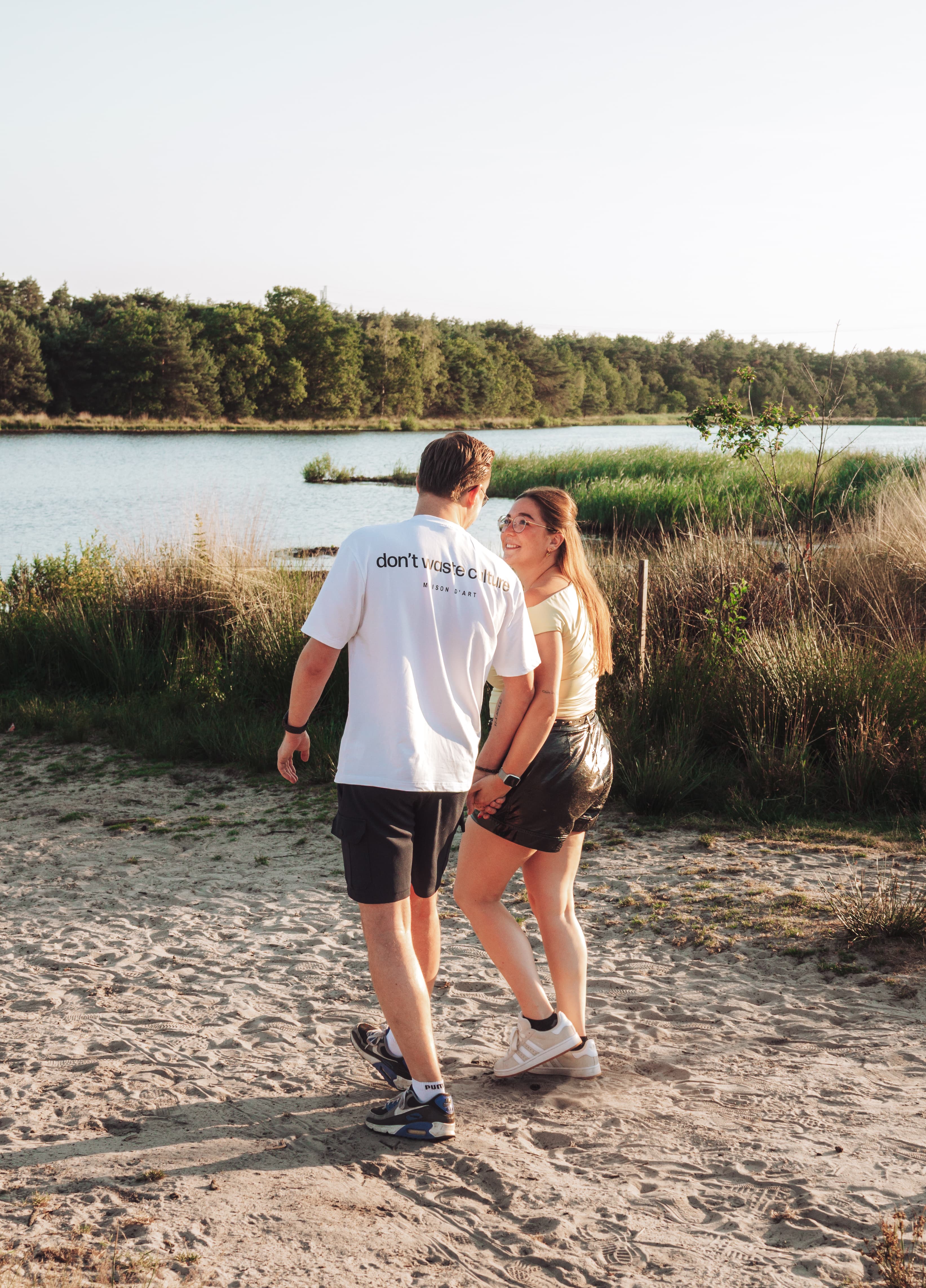Gezin van vier loopt hand in hand onder bloeiende appelbomen
